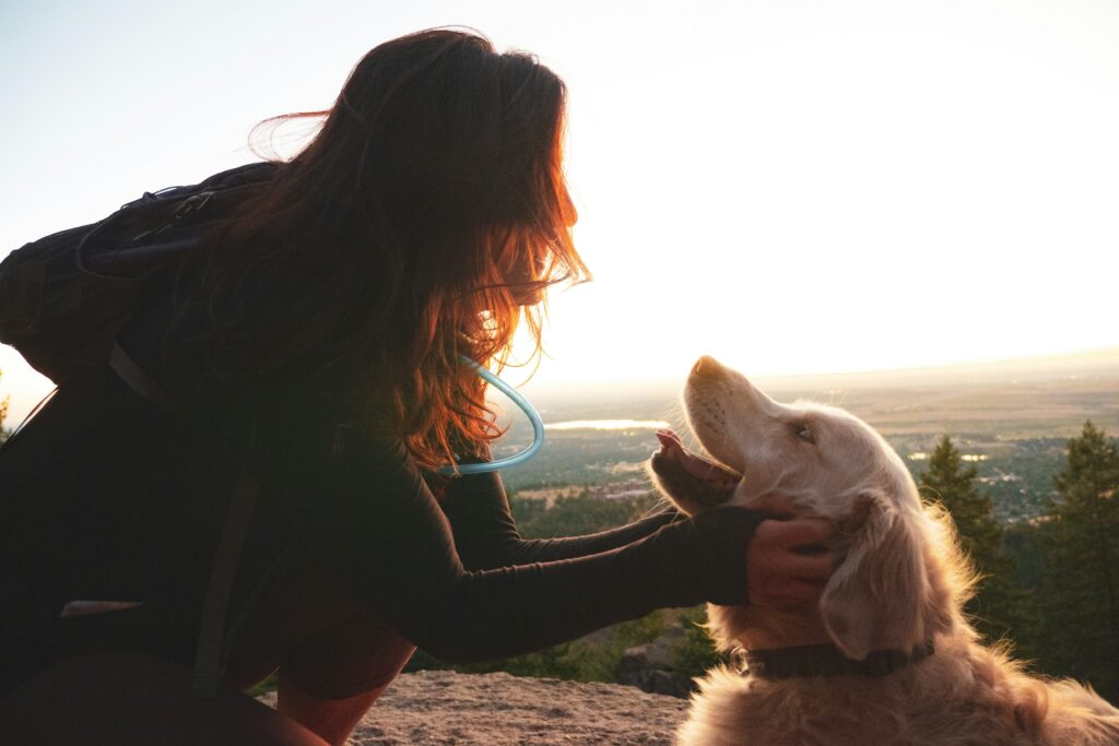 Woman joyfully interacts with her dog as the animal lovingly looks at her, representing co-regulation with pets.
